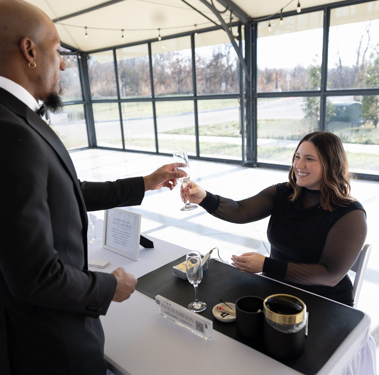 Guest receiving a personalized engraved champagne glass at Kansas City wedding cocktail hour