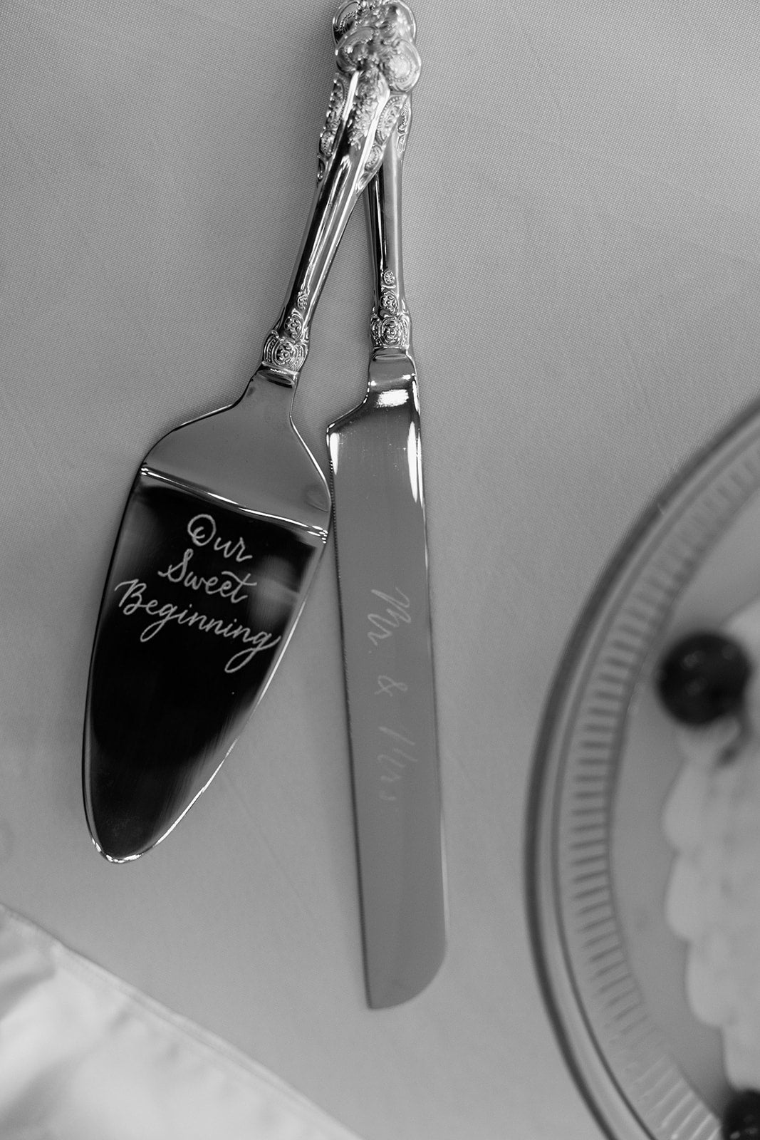 Silver cake cutting set with engraved text on a white background