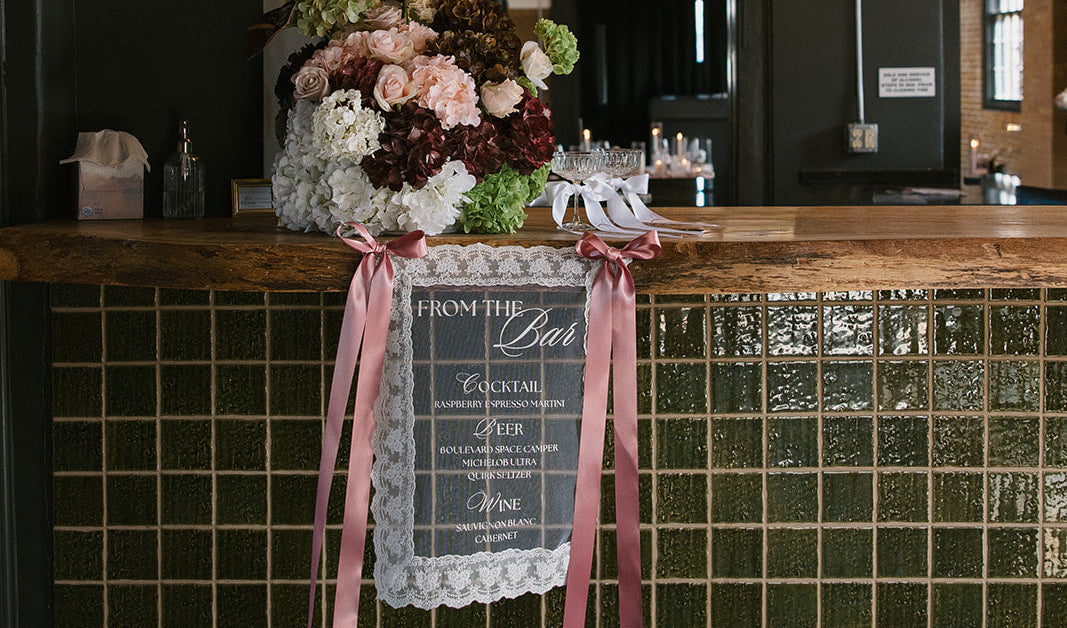 Fabric bar sign with floral arrangement at Kansas City wedding